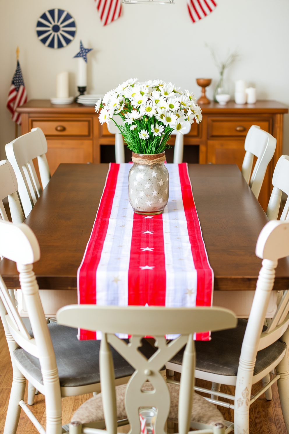 A festive dining table setting features a vibrant red white and blue table runner that stretches across the table. The runner is adorned with subtle star patterns, complementing a centerpiece of fresh white daisies in a rustic vase. Surrounding the table are mismatched chairs in soft neutral tones, creating an inviting atmosphere for guests. The backdrop includes subtle patriotic decorations, such as small flags and themed candles, enhancing the Memorial Day celebration.