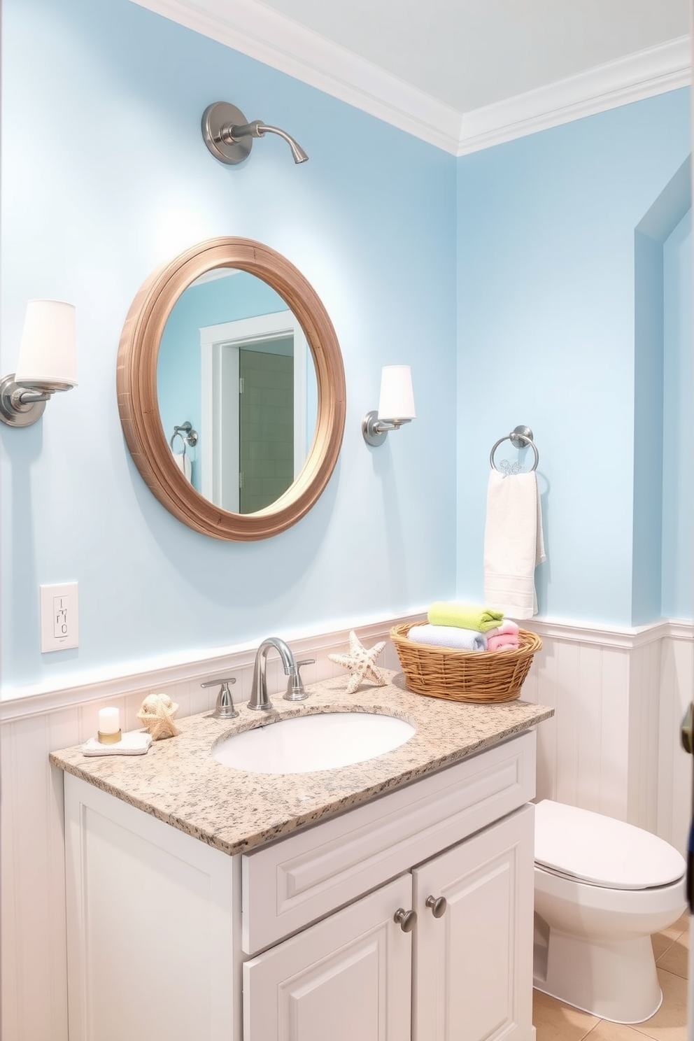 A bright and airy bathroom featuring beach-themed decor that exudes a summer vibe. The walls are painted in a soft sky blue, complemented by white wainscoting and seashell accents throughout the space. A large, round mirror with a driftwood frame hangs above a white vanity topped with a granite surface. Nautical elements such as starfish and coral are tastefully arranged on the countertop, while a woven basket holds fresh towels in pastel colors.