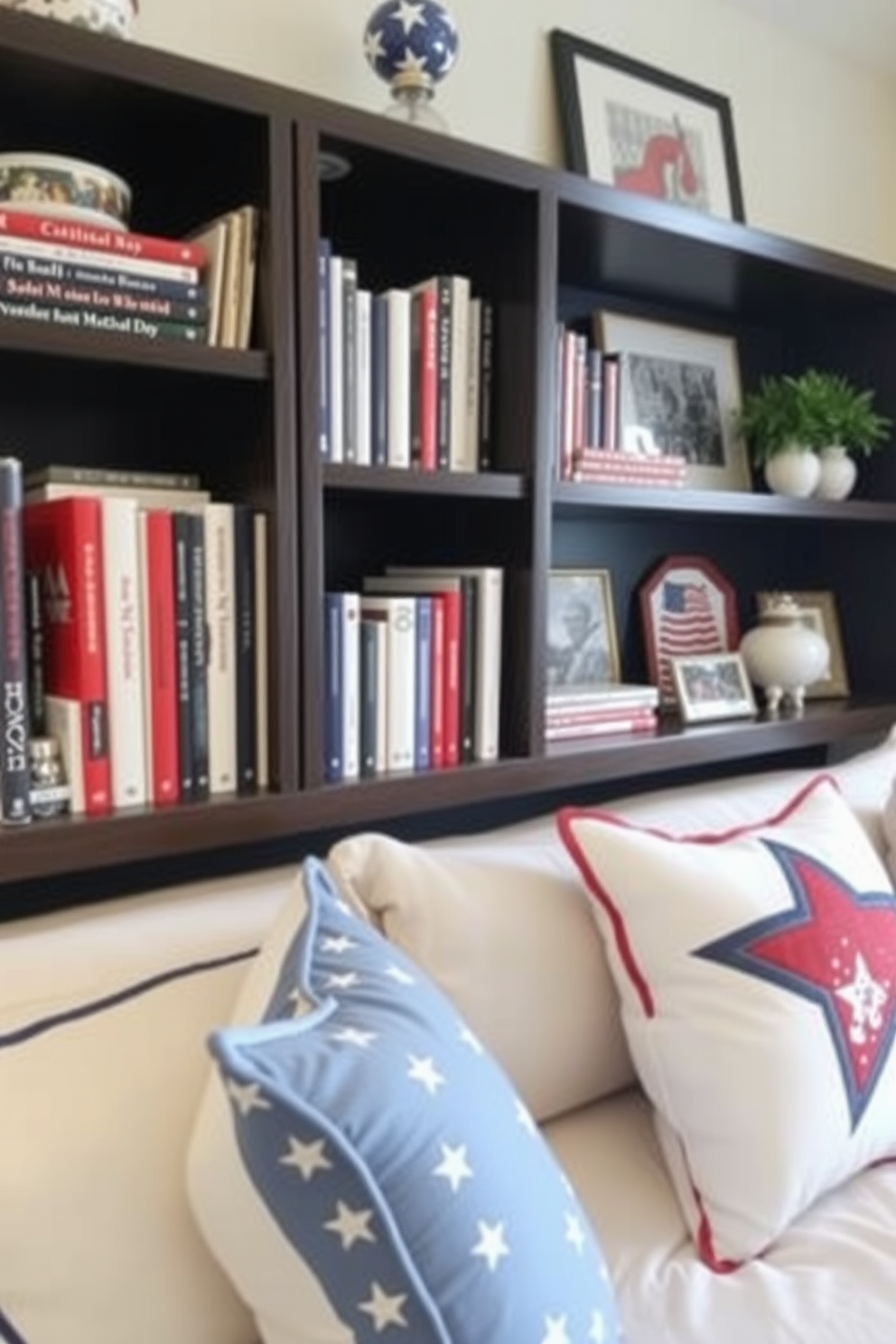 Patriotic themed bookends made of red white and blue ceramic stand proudly on dark wooden shelves. The shelves are filled with an array of books and small decorative items that reflect the spirit of Memorial Day. The bedroom features soft bedding in shades of blue and white with accents of red. A decorative throw pillow with a star pattern adds a festive touch to the overall decor.