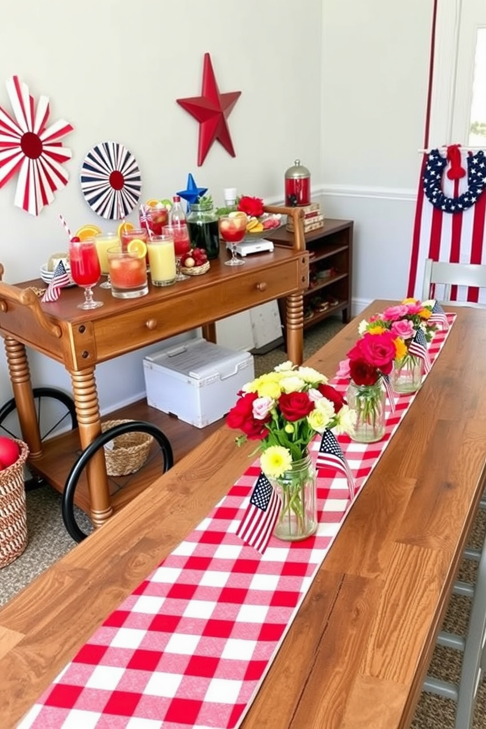 A patriotic themed cocktail station setup featuring a rustic wooden bar cart adorned with red white and blue decorations. The cart is topped with an array of colorful cocktails garnished with fresh fruit and herbs alongside festive paper straws. Memorial Day dining room decorating ideas showcasing a long wooden table set for a festive gathering. The table is adorned with a red and white checkered tablecloth and centerpieces of fresh flowers in mason jars complemented by small American flags.