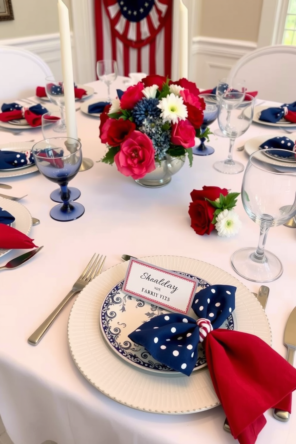 Create a beautifully arranged dining table for Memorial Day featuring a crisp white tablecloth and elegant blue and red accents. Each place setting includes a personalized name card elegantly displayed on a decorative plate, surrounded by fresh flowers and patriotic-themed napkins.