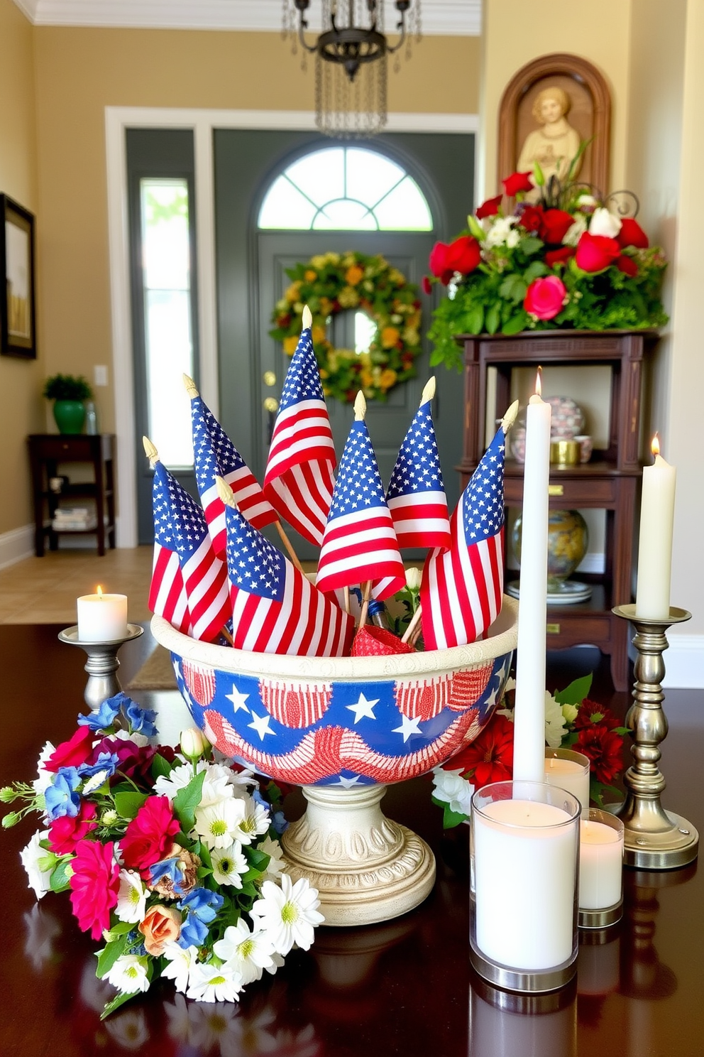 A decorative bowl filled with small American flags serves as a patriotic centerpiece in the entryway. Surrounding the bowl are seasonal flowers and candles that enhance the festive atmosphere for Memorial Day.