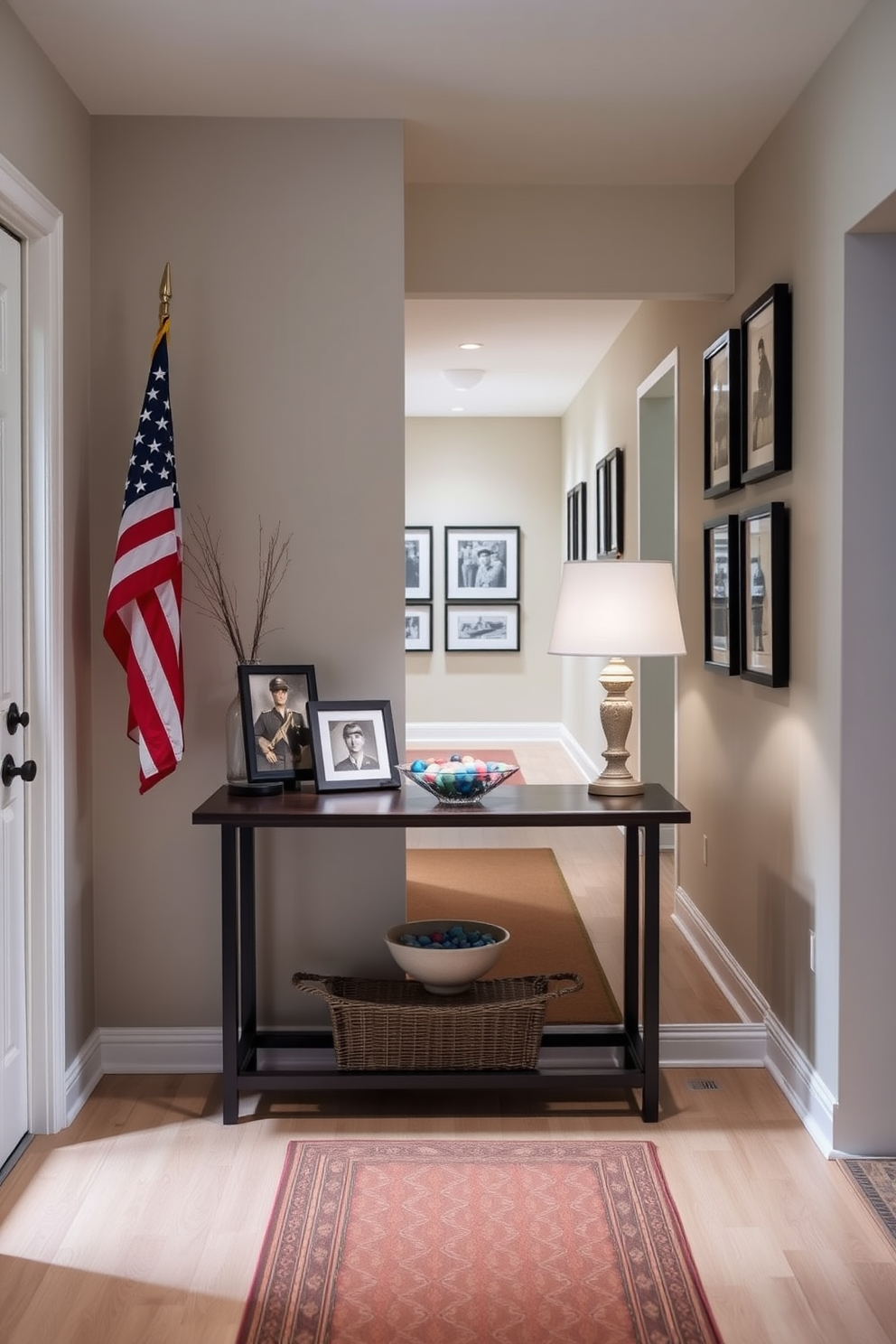 A welcoming entryway features a stylish table adorned with a tasteful tribute to service members. The table is decorated with a small American flag, framed photographs of veterans, and a decorative bowl filled with patriotic-colored stones. The hallway is lined with subtle lighting that highlights a series of framed artwork celebrating military history. Soft, neutral tones on the walls create a serene backdrop for the tribute, while a runner rug adds warmth and texture to the space.