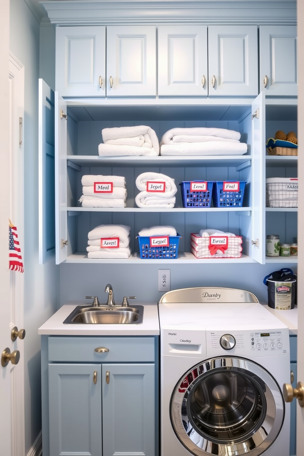 A bright and cheerful laundry room featuring functional storage solutions with festive labels for Memorial Day. The cabinets are painted in a soft blue, and open shelving displays neatly folded towels and colorful baskets labeled for easy access.