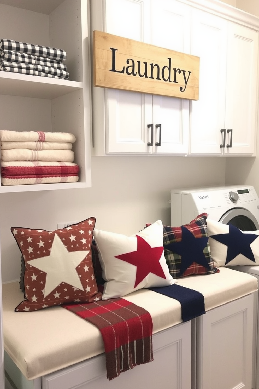 Festive throw pillows with stars are arranged on a cozy bench in the laundry room. The pillows feature a mix of red, white, and blue patterns that evoke a sense of celebration and patriotism. The laundry room is bright and cheerful, with white cabinetry and open shelving displaying neatly folded towels. A rustic wooden sign that reads 