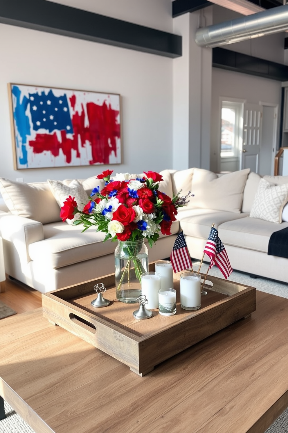 A chic loft living room features a stylish coffee table centerpiece that embodies the spirit of Memorial Day. The table is adorned with a rustic wooden tray holding vibrant red, white, and blue flowers in a glass vase alongside decorative candles and small American flags. Surrounding the coffee table, a plush sectional sofa in neutral tones invites relaxation, while a large abstract painting in patriotic colors hangs on the wall. Natural light pours in through expansive windows, enhancing the warm ambiance of the space.