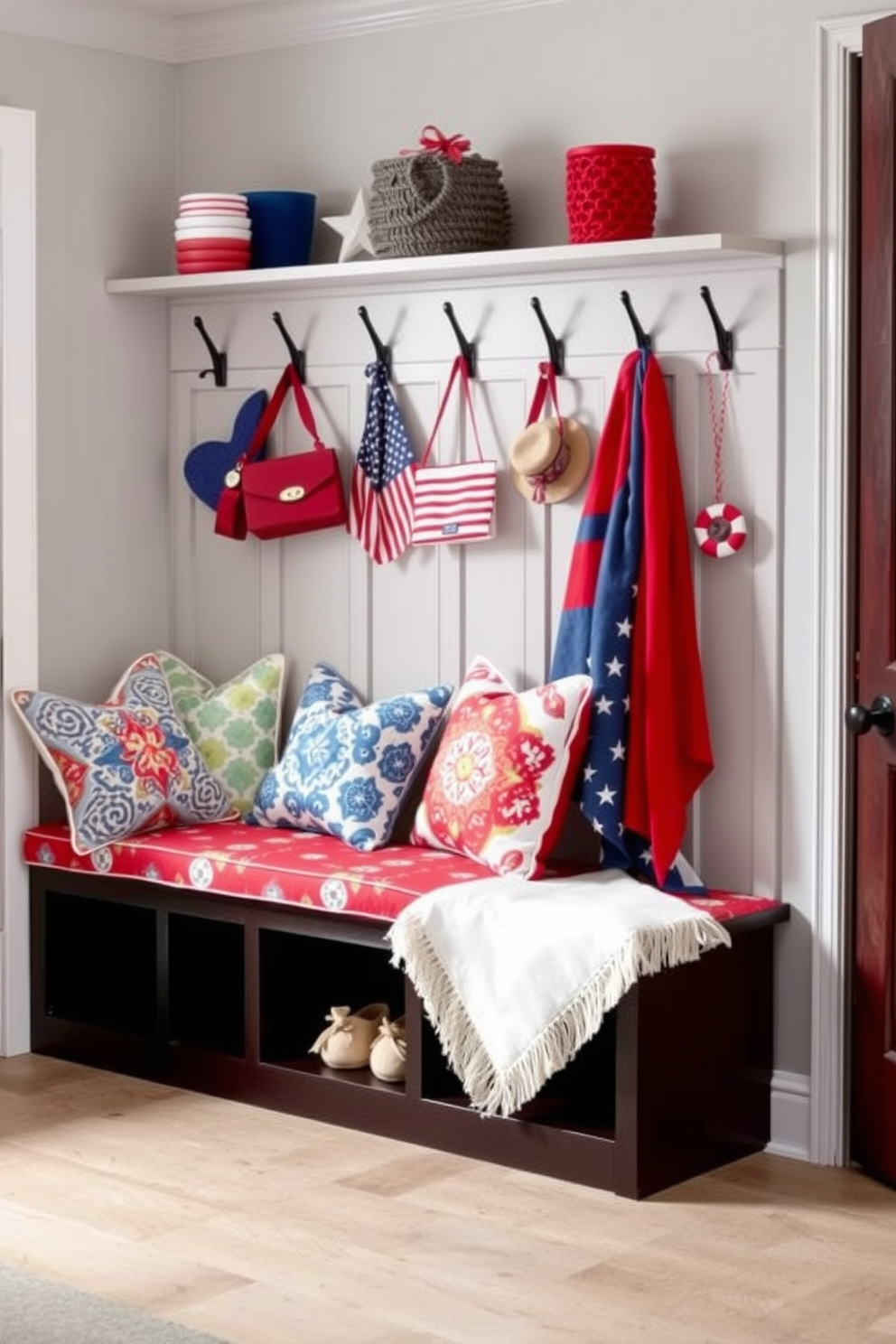 A cozy mudroom features bench seating adorned with colorful cushions in vibrant patterns. The walls are painted a soft gray, and decorative hooks display red, white, and blue accessories for a festive Memorial Day theme.