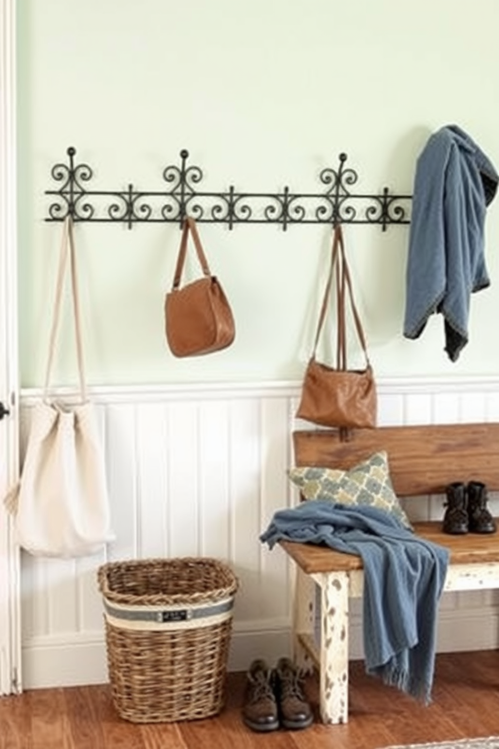 A cozy mudroom features vintage hooks made of wrought iron, perfectly positioned for hanging coats and bags. The walls are adorned with a soft pastel color, creating a welcoming atmosphere for family and guests. Decorative baskets are placed beneath the hooks, providing storage for shoes and outdoor gear. A rustic bench sits nearby, inviting visitors to sit and remove their footwear comfortably.