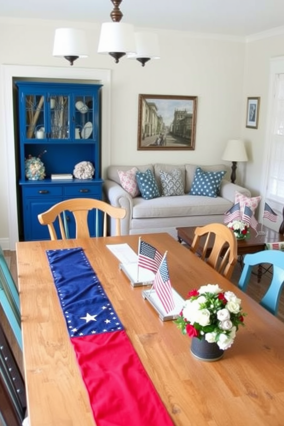 A festive table runner adorned with red white and blue flags stretches across a wooden dining table. Surrounding the table are mismatched chairs upholstered in cheerful patterns to create a warm inviting atmosphere. In the small living room a cozy arrangement of a plush sofa and patterned throw pillows enhances the patriotic theme. A coffee table decorated with small American flags and seasonal flowers adds a celebratory touch to the space.