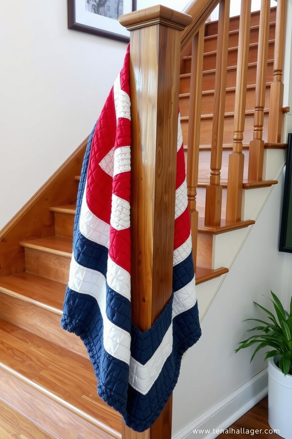 A cozy staircase adorned with a quilted throw in red, white, and blue creates a festive atmosphere for Memorial Day. The throw is draped elegantly over the banister, complementing the wood tones of the staircase and adding a touch of patriotic charm.