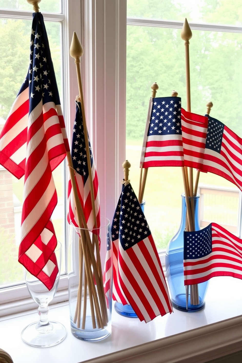 A collection of vintage American flags is artfully arranged in elegant glass vases placed on a windowsill. The vases are different heights, creating visual interest, and the flags add a patriotic touch to the festive Memorial Day decor.