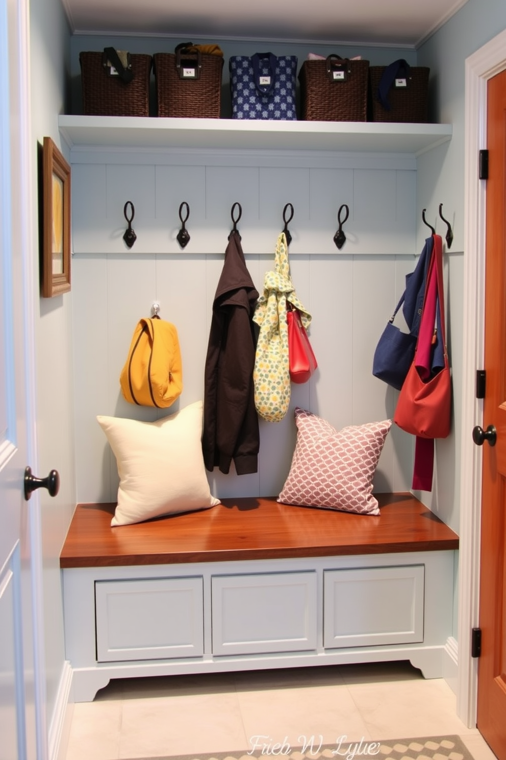 A charming mudroom features a small wooden bench with soft cushions for comfortable seating. The walls are painted a fresh light blue, and decorative hooks hold colorful jackets and bags.