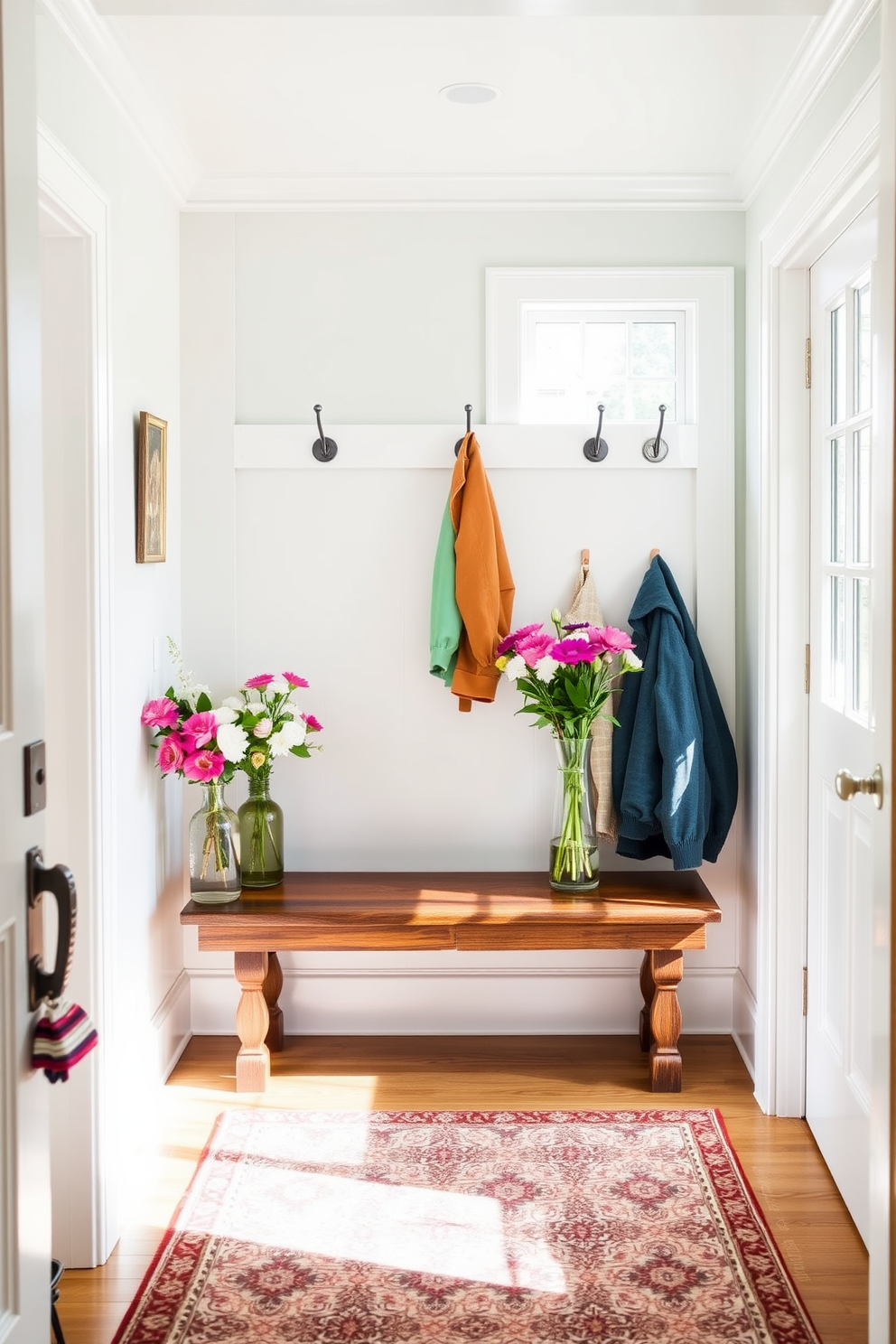 A bright and airy mudroom filled with natural light. Fresh flowers in elegant vases adorn the rustic wooden bench, adding a touch of color and life to the space. The walls are painted in a soft pastel hue, creating a warm and inviting atmosphere. Stylish hooks line the wall, displaying colorful jackets and accessories, while a patterned rug adds texture underfoot.