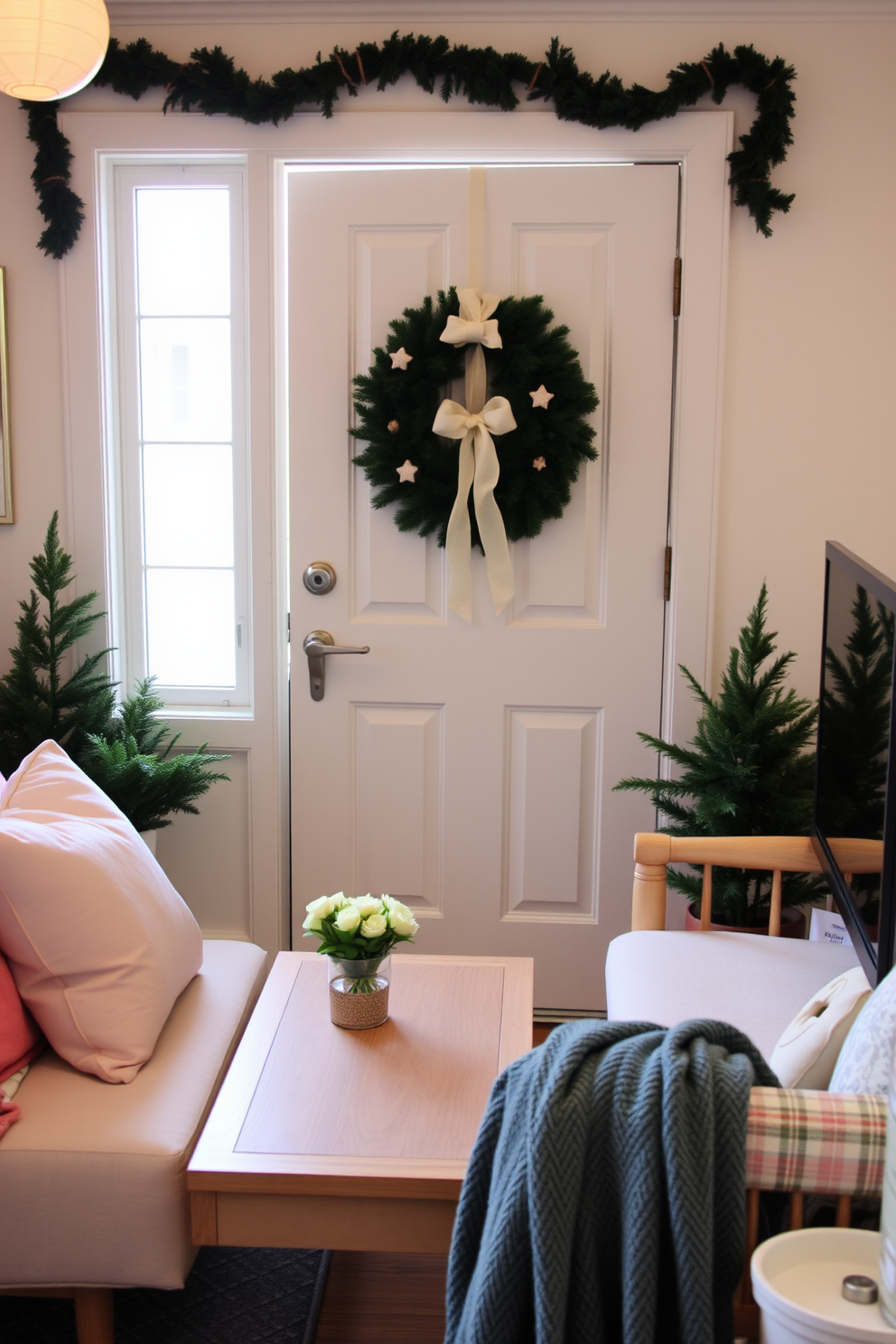 A charming small living room adorned with a seasonal wreath on the front door. The space features a cozy seating arrangement with pastel-colored cushions and a light wooden coffee table.