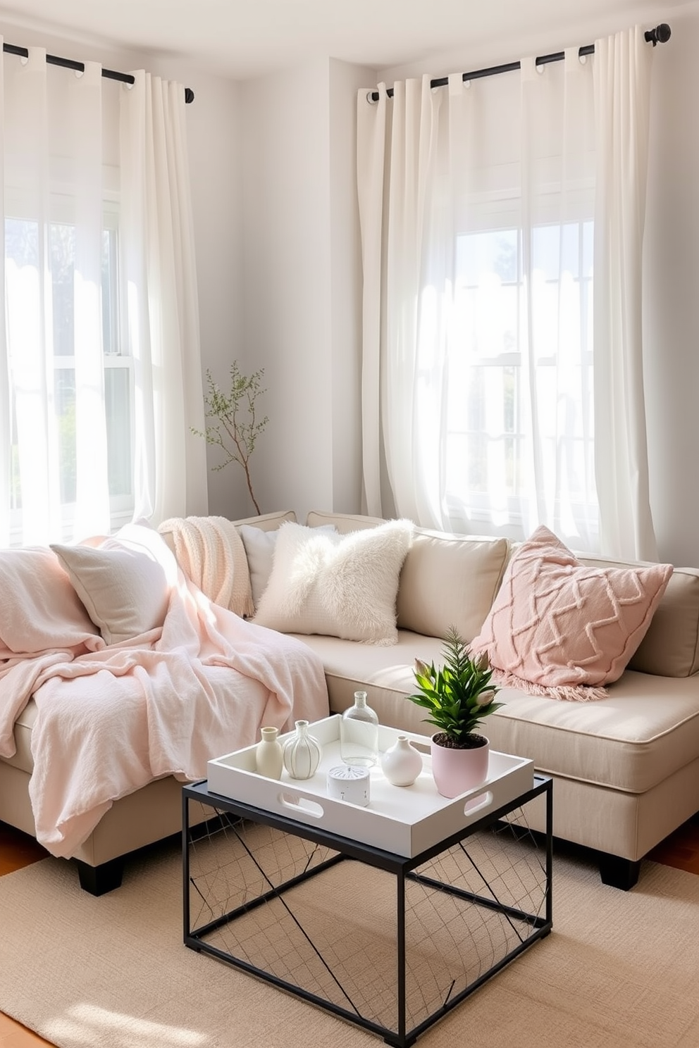 A bright and airy small space living area. Soft pastel-colored lightweight blankets are draped over a cozy sectional sofa, complemented by fluffy throw pillows in varying textures. A small coffee table sits in front of the sofa, adorned with a stylish tray holding a few decorative items and a fresh plant. Natural light floods the room through sheer curtains, enhancing the cheerful ambiance of the spring season.