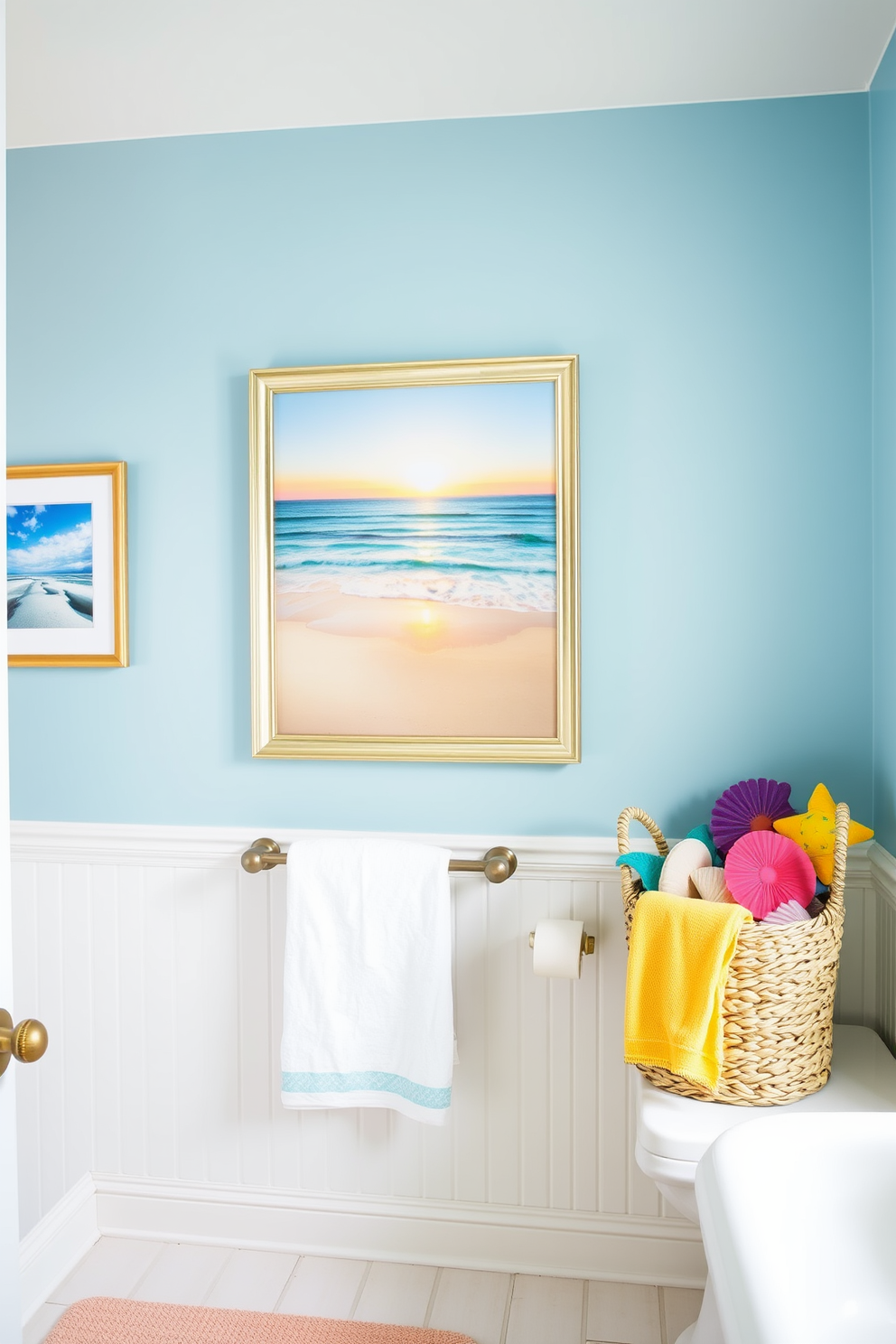 A bright and airy bathroom adorned with artwork featuring serene ocean scenes. The walls are painted in a soft blue hue, complementing the coastal theme, while a large framed painting of a beach sunset serves as the focal point above the towel rack. Incorporate summer bathroom decorating ideas such as seashell accents and vibrant, colorful towels. A woven basket filled with beach-themed decor sits in one corner, enhancing the relaxed, summery vibe of the space.