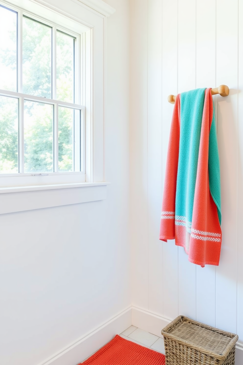 A bright and airy summer bathroom features vibrant towels in shades of coral and turquoise hanging neatly on a wooden towel rack. The walls are painted in a soft white, complemented by a large window that lets in plenty of natural light, creating a refreshing and cheerful atmosphere.