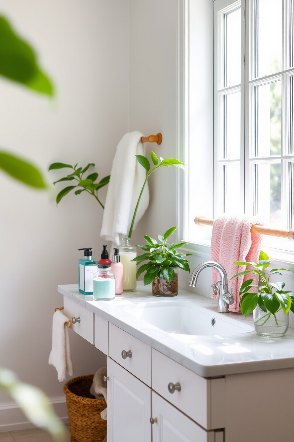 A bright summer bathroom filled with natural light. Glass containers elegantly display colorful toiletries on a white marble countertop. Fresh green plants are placed strategically around the space to enhance the summer vibe. Soft, fluffy towels in pastel shades hang neatly on a wooden rack.