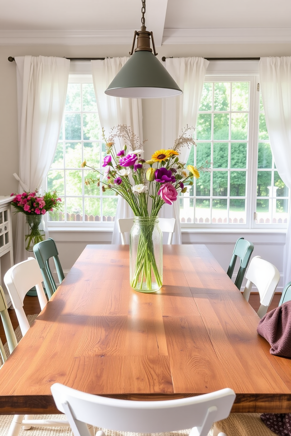 A charming summer dining room features a rustic farmhouse table made of reclaimed wood, surrounded by mismatched chairs that add character. Sunlight streams through large windows adorned with light, airy curtains, illuminating a centerpiece of fresh wildflowers in a mason jar.