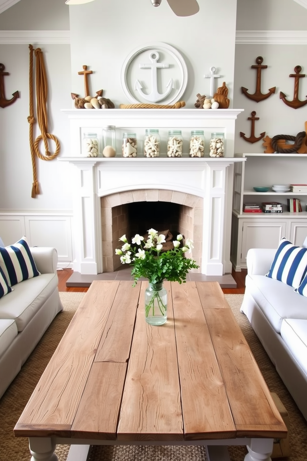 A bright and airy living room features nautical decor with ropes and anchors adorning the walls. A large, weathered wooden coffee table sits in the center, surrounded by comfortable white sofas with blue and white striped cushions. The mantel above the fireplace is beautifully decorated for summer with a collection of seashells and starfish in glass jars. Fresh greenery and small white flowers in a simple vase add a touch of elegance to the summer theme.