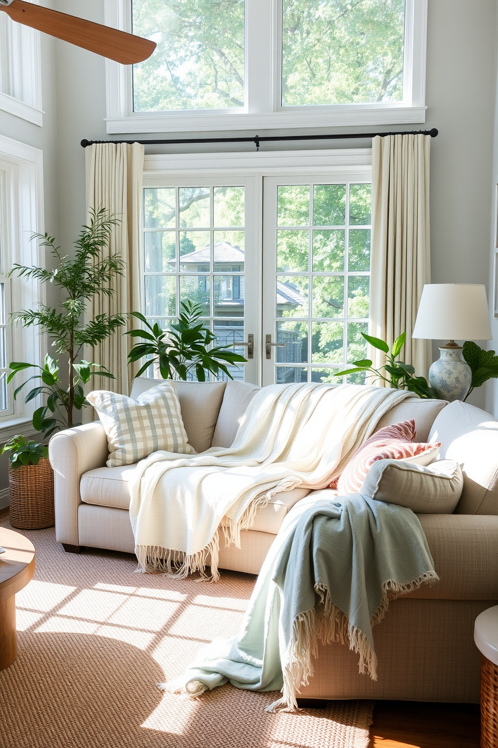 A cozy summer living room featuring lightweight throws draped over a plush sofa. The space is adorned with bright, airy colors and natural light streaming through large windows, creating an inviting atmosphere.