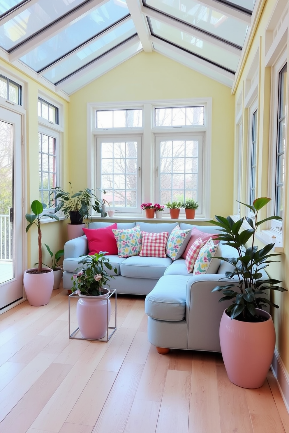 A cozy sunroom filled with natural light. The walls are painted in soft pastel yellow, and the floor is adorned with light wood planks. A comfortable seating area features a plush pastel blue sofa with colorful throw pillows. Potted plants in pastel pink and lavender ceramic pots add a touch of greenery and vibrancy.