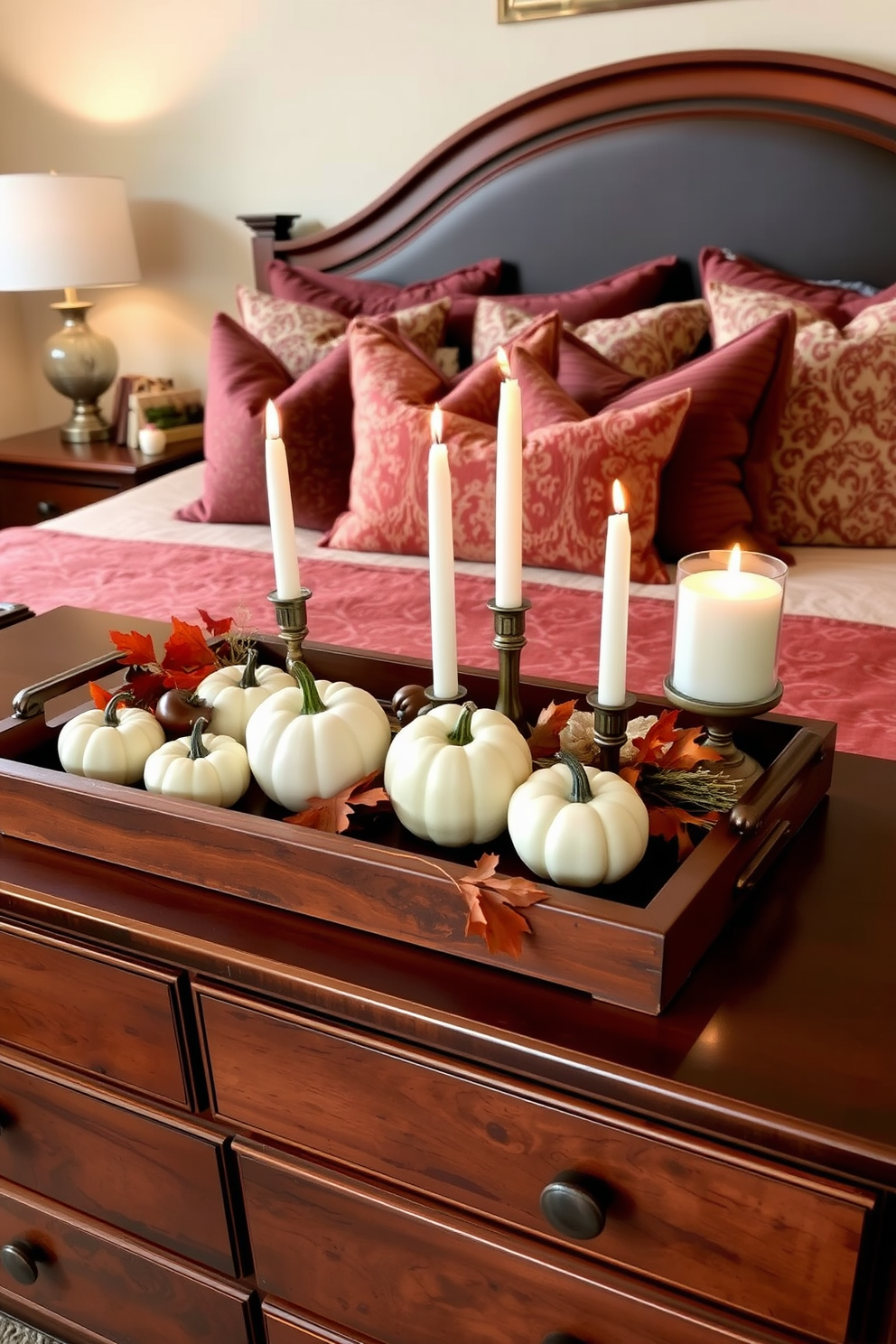 Decorative trays placed on a wooden dresser adorned with seasonal items for Thanksgiving. The tray features small pumpkins, autumn leaves, and scented candles, creating a warm and inviting atmosphere in the bedroom. The bedding is in rich, earthy tones complemented by decorative pillows that echo the colors of fall. Soft lighting from bedside lamps enhances the cozy ambiance, making the space perfect for relaxation and celebration.