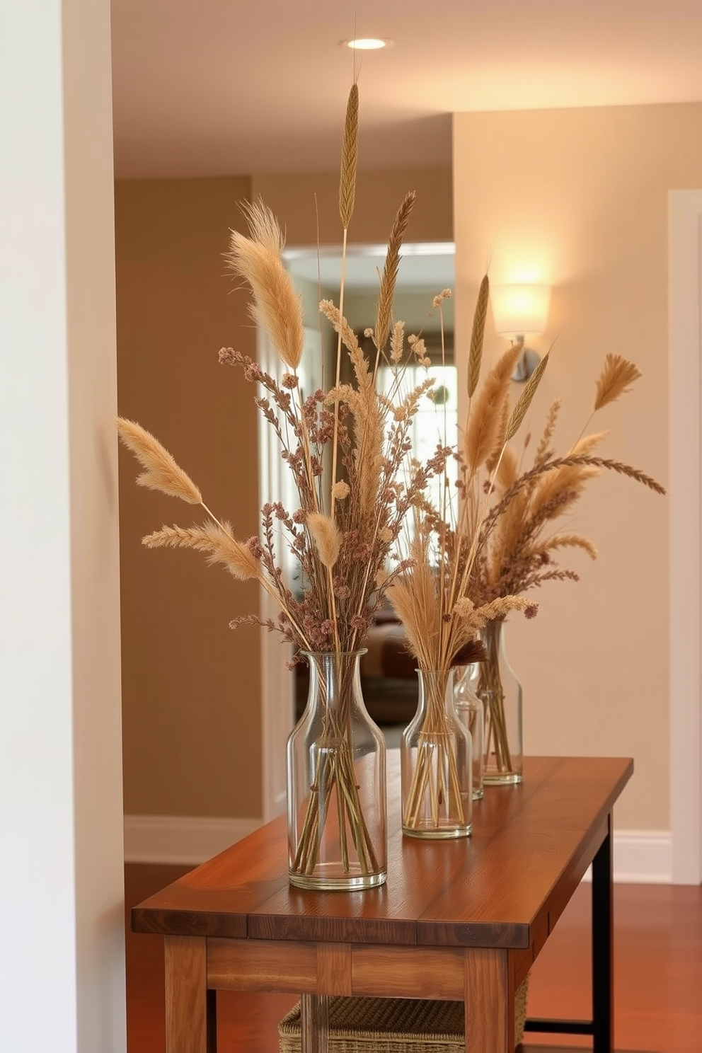 A warm and inviting hallway adorned with glass vases filled with dried flowers and grasses. The vases are artfully arranged on a wooden console table, complemented by soft lighting that highlights their natural textures.