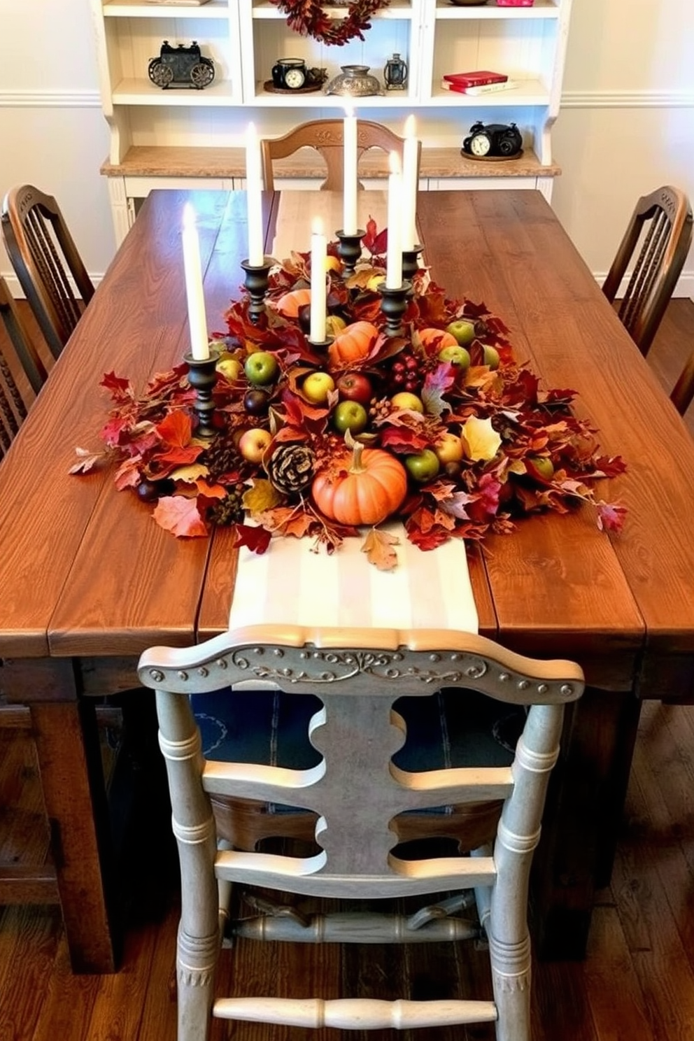 A rustic wooden table is adorned with an elegant centerpiece featuring autumn leaves, candles, and seasonal fruits. Surrounding the table, mismatched chairs create a cozy and inviting atmosphere for Thanksgiving gatherings.