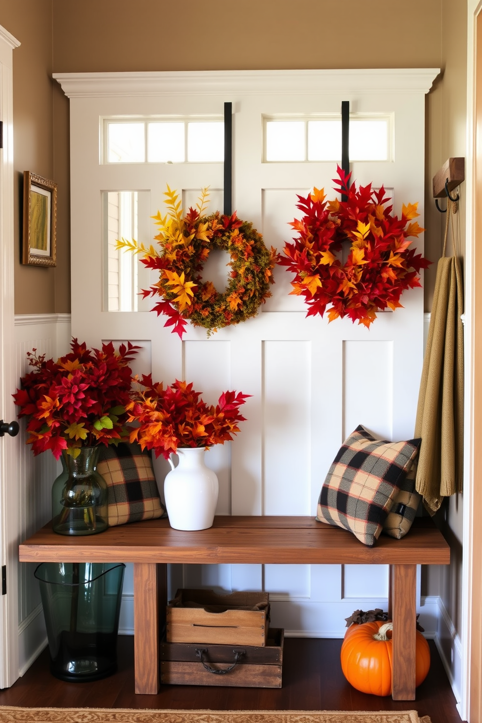 A cozy mudroom decorated for Thanksgiving features vases filled with vibrant fall foliage in rich reds, oranges, and yellows. The space includes a rustic bench with plaid cushions and a warm, inviting color palette that enhances the seasonal theme.