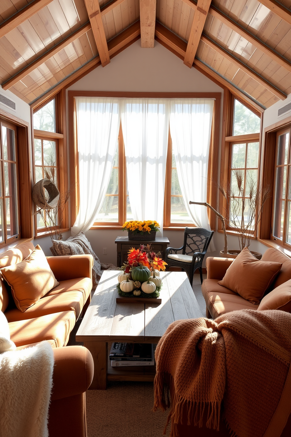 A cozy sunroom filled with natural light. The space features large windows adorned with sheer white curtains that gently diffuse the sunlight. Natural wood accents are incorporated throughout, including a reclaimed wood coffee table and wooden beams on the ceiling. Plush seating in warm tones invites relaxation and conversation. Decorative elements include a harvest-themed centerpiece on the table, showcasing pumpkins and autumn foliage. Soft throw blankets in earthy colors are draped over the furniture for added comfort.