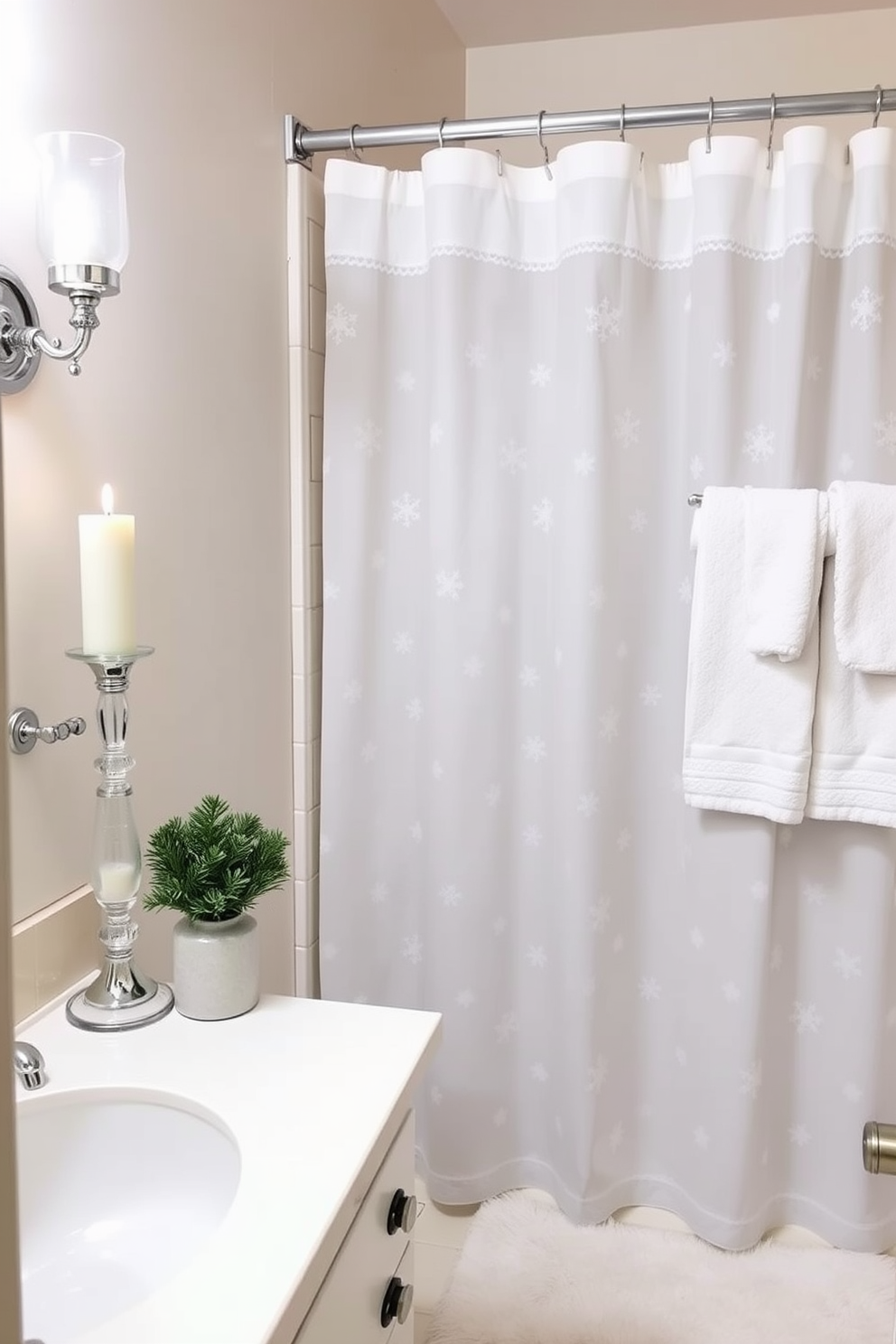 Frosted glass decor creates a serene winter atmosphere. The bathroom features frosted glass candle holders and a shower curtain with delicate snowflake patterns. Soft white towels and a plush bath mat complement the frosted elements. A small potted evergreen sits on the vanity for a touch of seasonal charm.