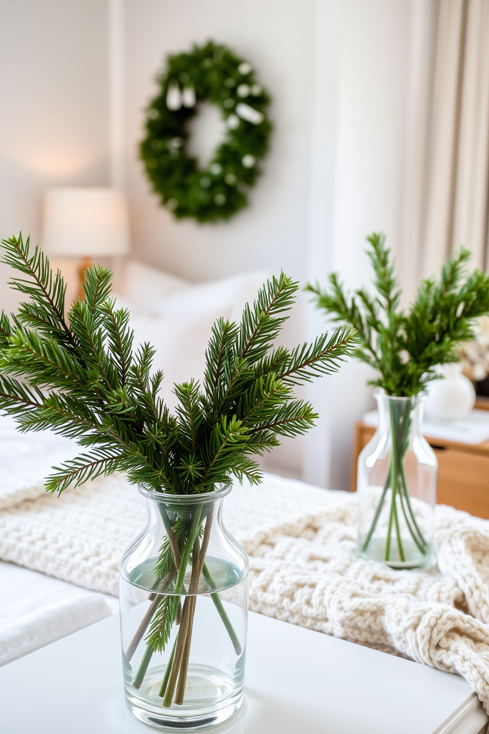 A cozy winter bedroom decorated with seasonal greenery in decorative vases. The room features a plush bed with soft white linens and a chunky knit throw, while vibrant evergreen branches are arranged in elegant glass vases on the nightstands.