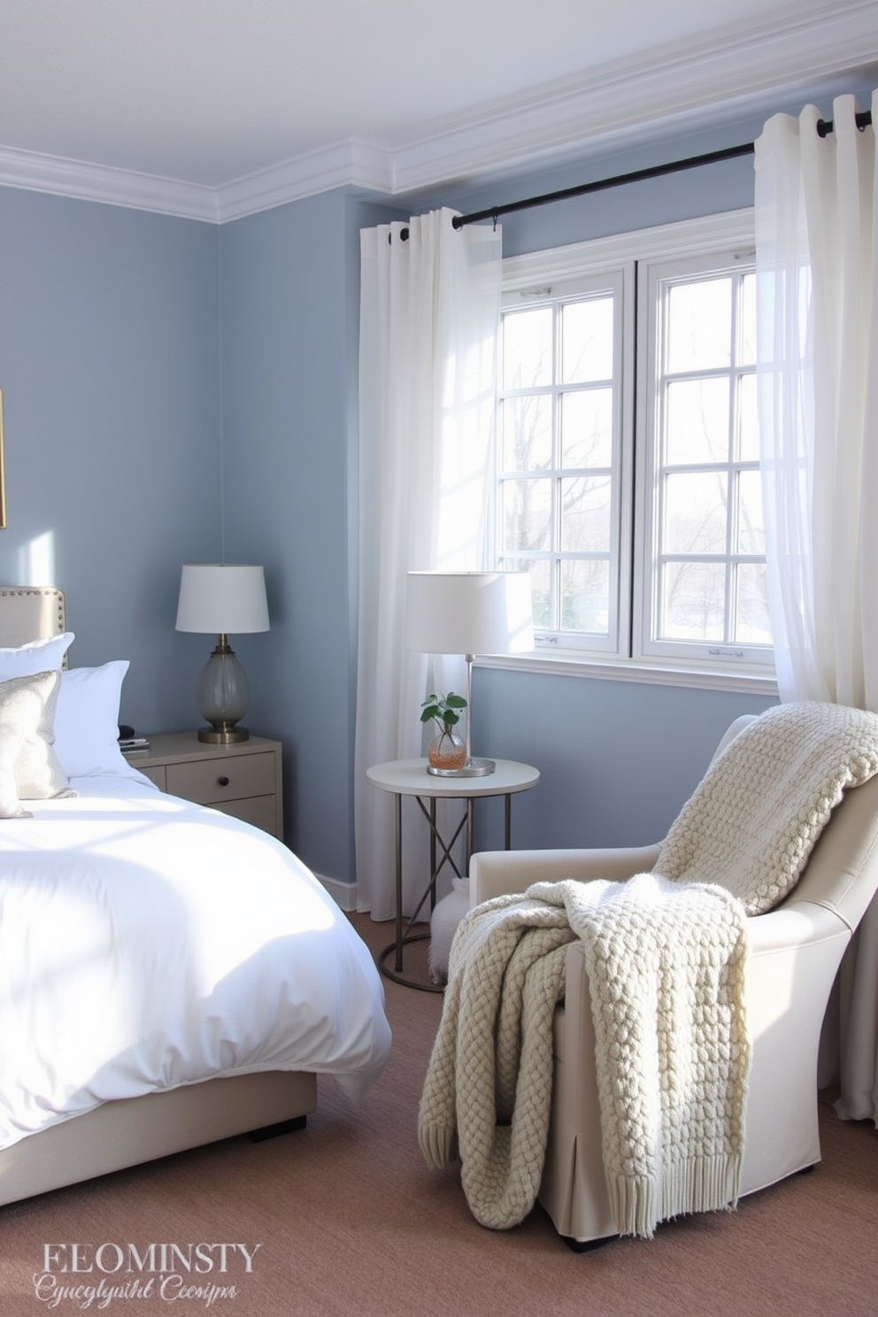 Create a serene bedroom with winter hues. The walls are painted in a soft icy blue, complemented by crisp white bedding and plush gray throw pillows. A large window allows natural light to fill the room, adorned with sheer white curtains that flutter gently. A cozy armchair in the corner is draped with a chunky knit blanket, inviting relaxation on cold winter days.