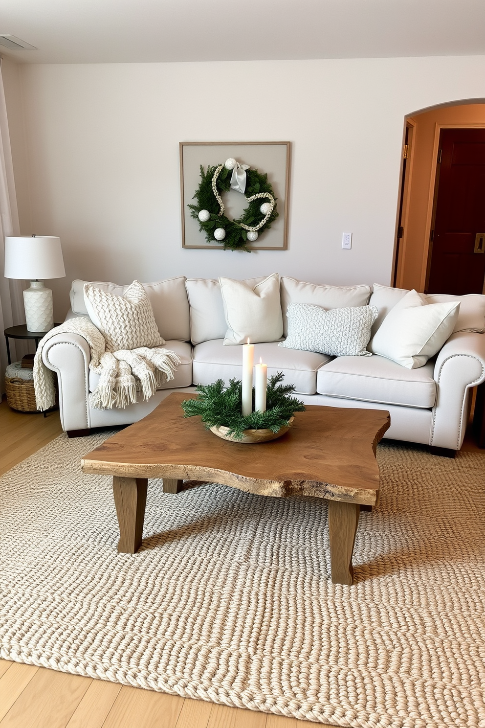 A cozy living room adorned in neutral tones with soft beige and creamy white accents. A plush sectional sofa is complemented by a chunky knit throw and a pair of textured pillows, creating an inviting atmosphere. A rustic wooden coffee table sits at the center, topped with a few carefully arranged candles and a small evergreen centerpiece. The space is illuminated by warm lighting, enhancing the serene winter ambiance while a woven area rug adds warmth underfoot.