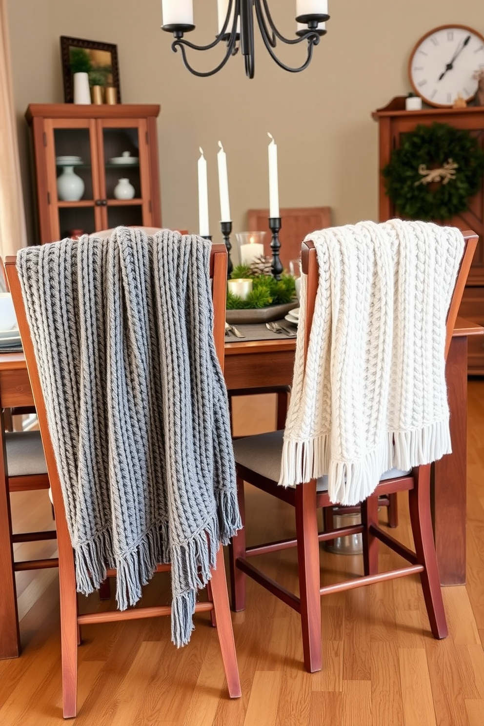 Cozy knit throws drape elegantly over the backs of wooden dining chairs. The table is set with rustic dinnerware and a centerpiece of pinecones and candles, creating a warm and inviting atmosphere.