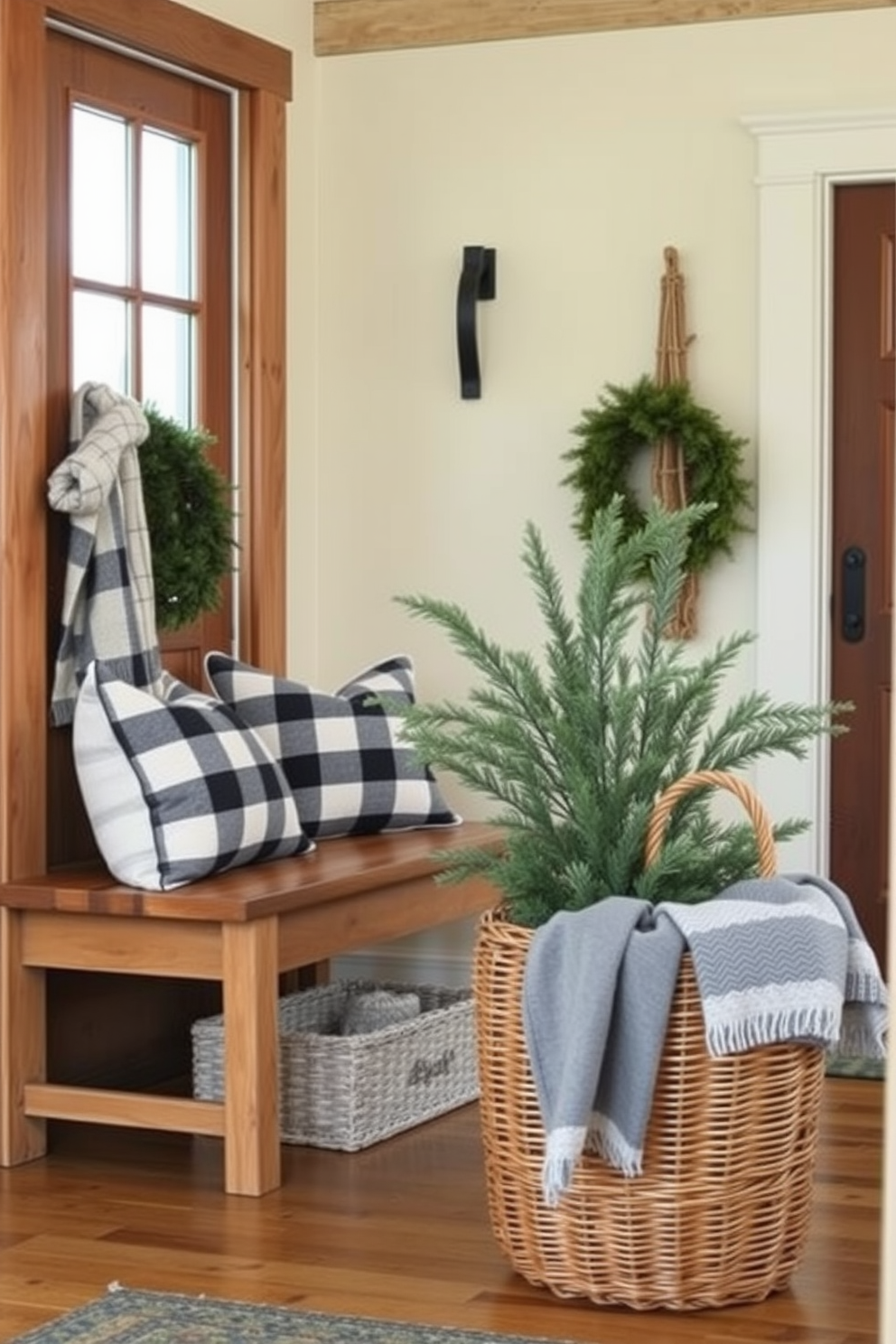 A cozy winter entryway features natural wood elements that exude rustic charm. A wooden bench sits against the wall, adorned with soft plaid cushions and a knitted throw blanket. Pine branches and seasonal greenery are arranged in a large wicker basket near the door. The walls are painted in a warm cream color, enhancing the inviting atmosphere of the space.