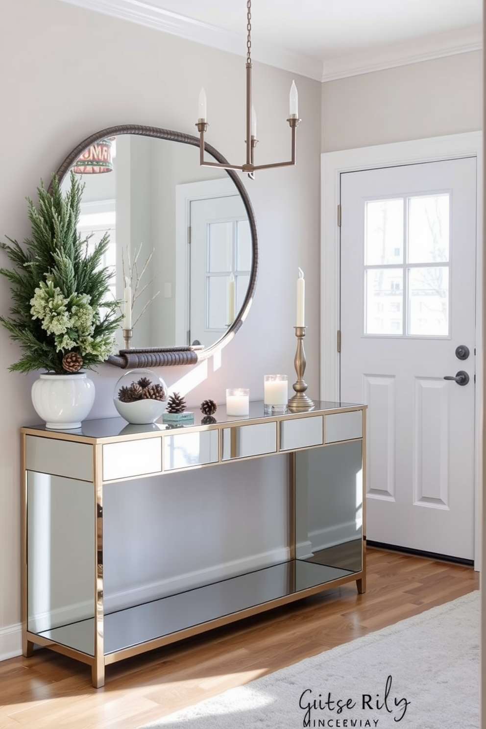 A winter entryway features mirrored accents that enhance the natural light and create an inviting atmosphere. The space includes a sleek console table with a mirrored surface, adorned with seasonal decorations like pinecones and candles.