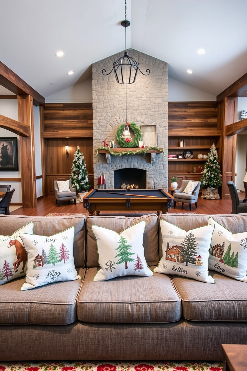 Seasonal throw pillows with winter motifs are scattered across a plush gray sectional sofa, adding warmth and comfort to the space. The pillows feature designs of snowflakes, pine trees, and cozy cabins, creating a festive atmosphere. The game room is adorned with rustic wooden accents and a large stone fireplace as a focal point. A pool table sits in the center, surrounded by soft lighting and winter-themed decor, enhancing the inviting ambiance for gatherings.