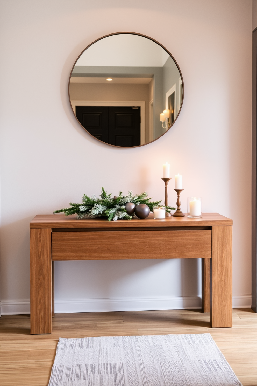 A sleek console table made of polished wood stands elegantly against a soft gray wall. Above the table, a large round mirror reflects warm ambient lighting, while a few carefully arranged decorative items add a touch of personality. In the winter hallway, the console table is adorned with seasonal decor, including a frosted evergreen centerpiece and cozy candles. A stylish runner rug in muted tones adds warmth and invites guests into the space.