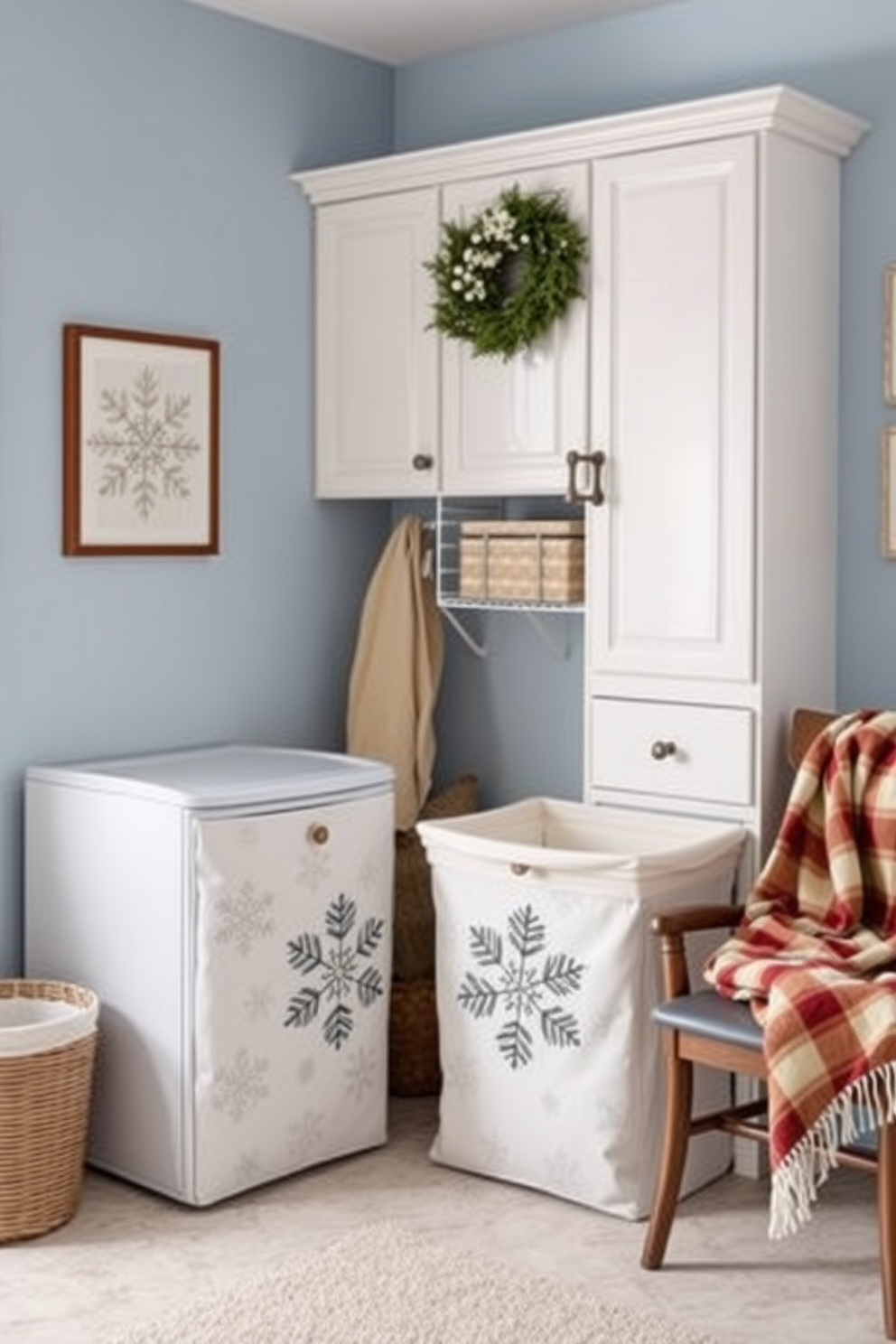 A cozy laundry room featuring winter-themed prints on stylish hampers. The walls are painted in a soft blue hue, complementing the white cabinetry and adding a touch of seasonal charm. Decorative elements include snowflake motifs and pinecone designs on the hampers. A warm throw blanket drapes over a nearby chair, enhancing the inviting atmosphere of the space.