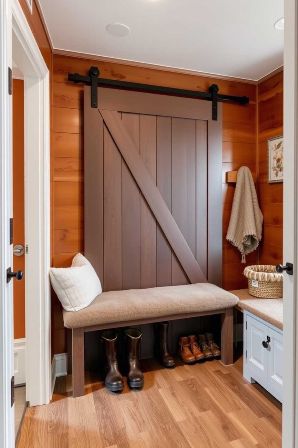 A cozy winter mudroom features a sliding barn door that effortlessly separates the space while adding rustic charm. The walls are adorned with warm wood paneling, and a plush bench with storage underneath invites guests to sit and remove their boots.