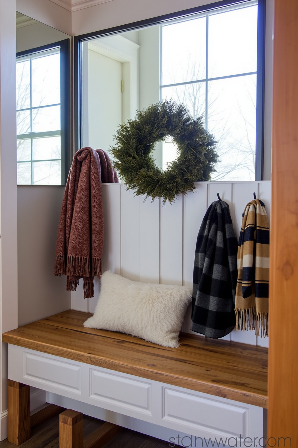 A cozy winter mudroom featuring a mirrored wall that reflects natural light and creates an inviting atmosphere. The space includes a rustic wooden bench with plush cushions and hooks for hanging winter coats and scarves.