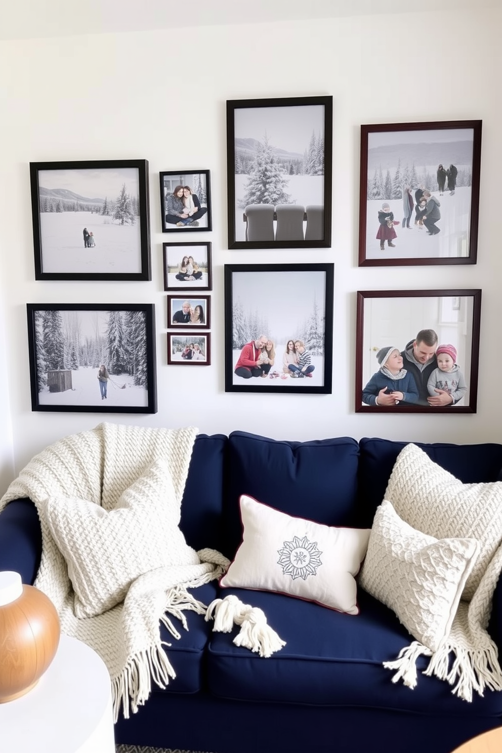 A cozy winter-themed small living room adorned with framed family photos showcasing snowy landscapes and festive gatherings. The walls are painted in soft white, and a plush navy blue sofa is accented with knitted throw blankets and seasonal cushions.