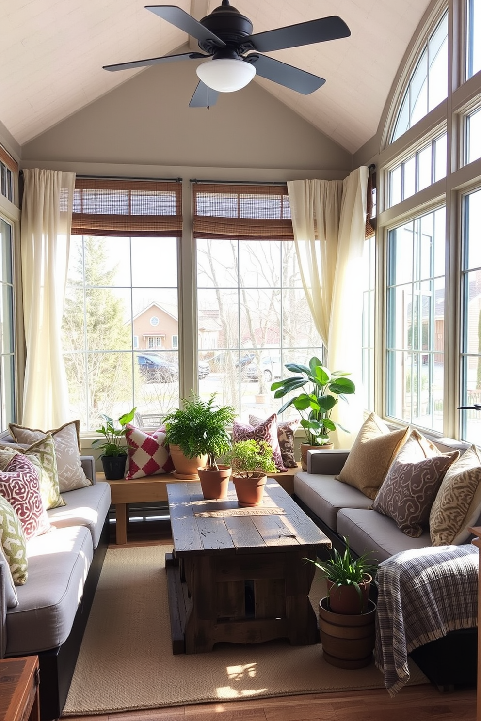 A cozy winter sunroom filled with natural light. The space features a comfortable seating area with an array of patterned pillows in various colors and textures, adding visual interest and warmth. Large windows draped with sheer curtains allow the soft winter sun to filter in. A rustic coffee table sits in the center, surrounded by potted plants that bring a touch of greenery indoors.