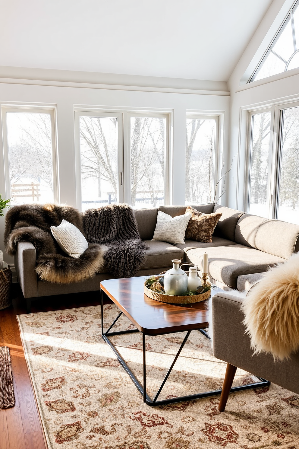 A winter sunroom filled with natural light, featuring plush faux fur throws draped over a modern sectional sofa. The space includes a stylish coffee table adorned with seasonal decor and a cozy area rug that complements the warm tones of the room.