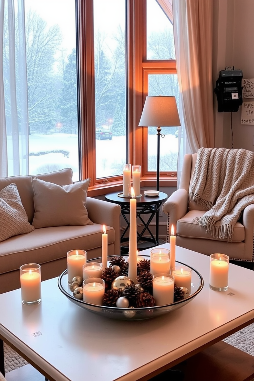 A cozy living room adorned for winter with a large window showcasing a snowy landscape. Soft sheer curtains frame the window while a plush armchair sits nearby, draped with a knitted throw blanket. On the coffee table, an arrangement of scented candles in varying heights creates a warm and inviting atmosphere. A decorative bowl filled with pinecones and seasonal ornaments adds a touch of festive charm.